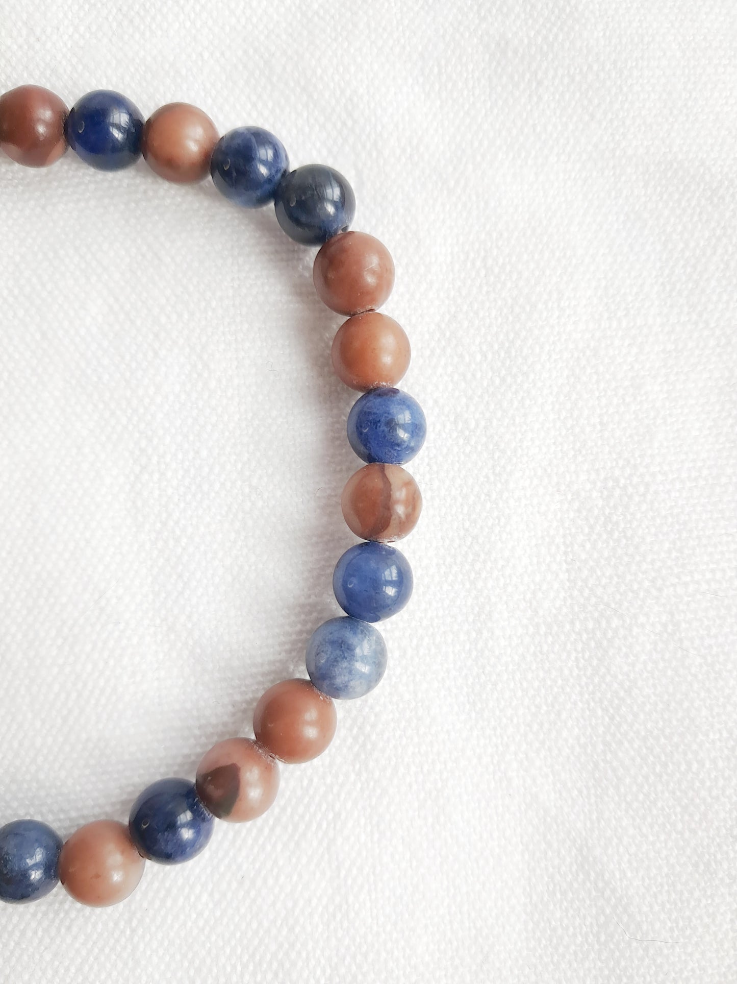 Détail des perles en sodalite et en bois rouge brun