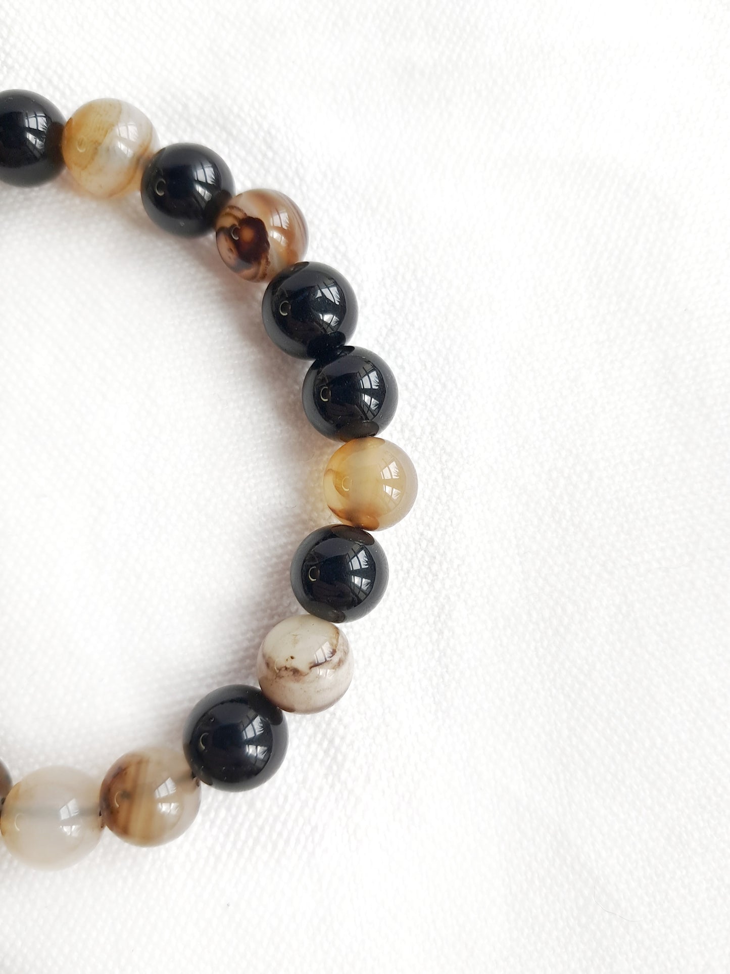 Détail des perles en obsidienne et agate café