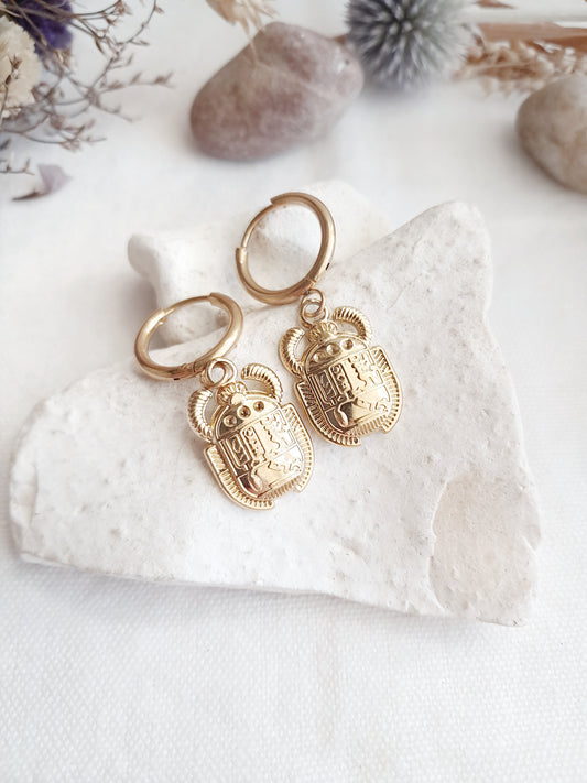 Ces boucles d'oreilles créoles scarabées égyptiens sont en acier inoxydable doré