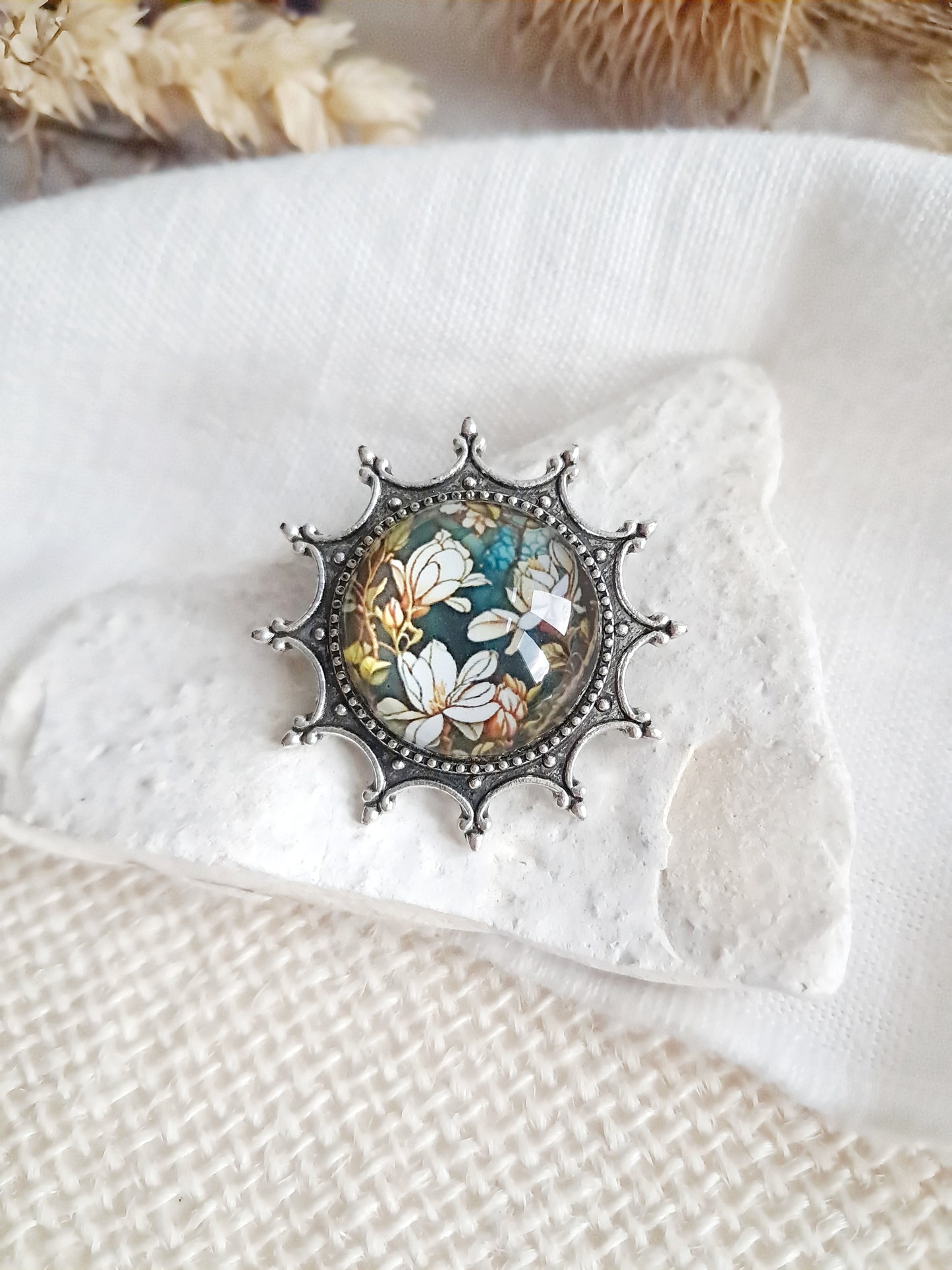Broche cabochon fleurs de magnolia sur un support médiéval gothique