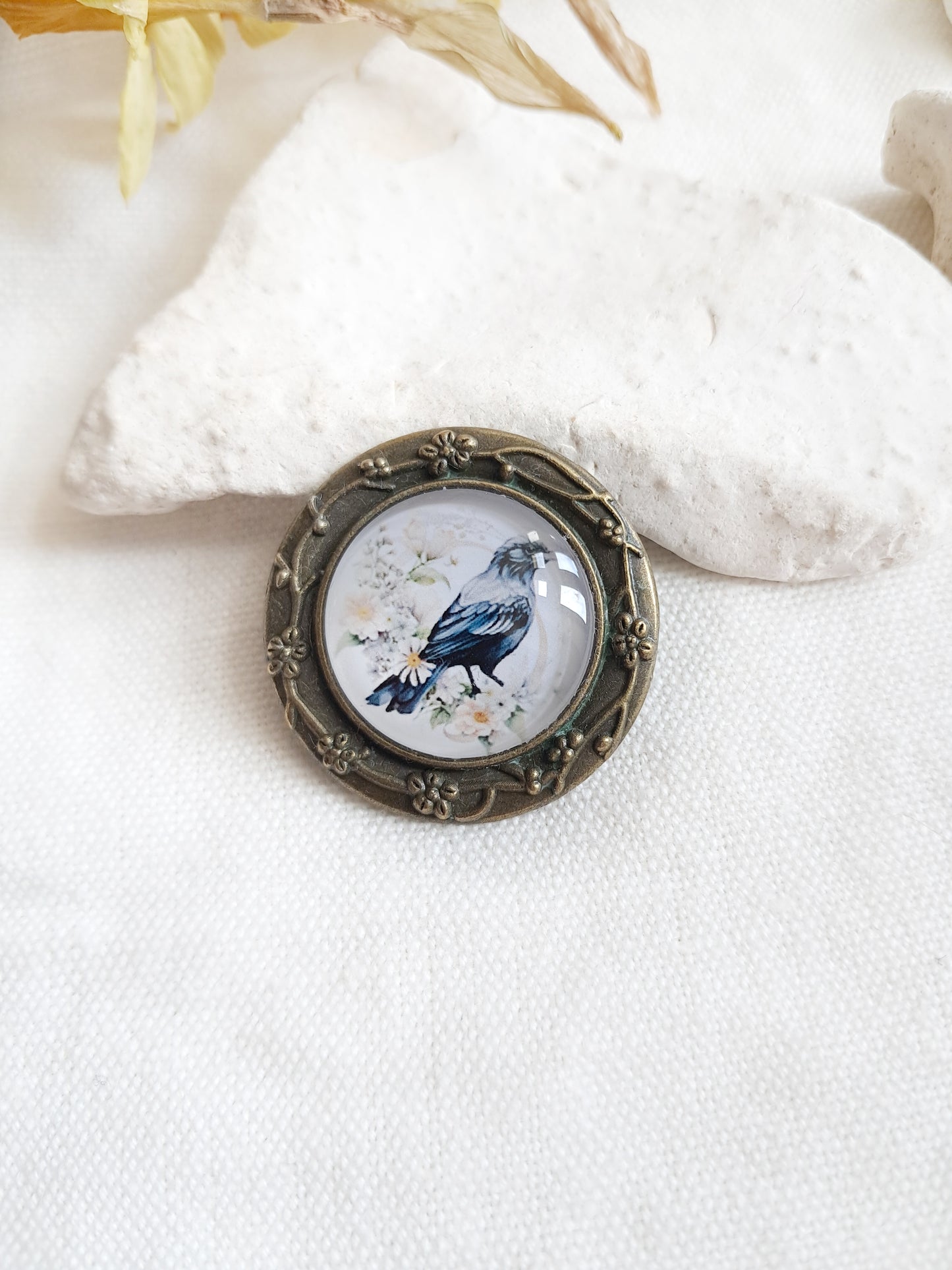 Broche cabochon oiseau corbeau et fleurs